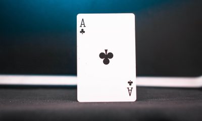 悬疑影视场景中扑克牌52张散落在审讯桌上，灯光昏黄营造紧张氛围，象征52在推理剧中的关键道具地位